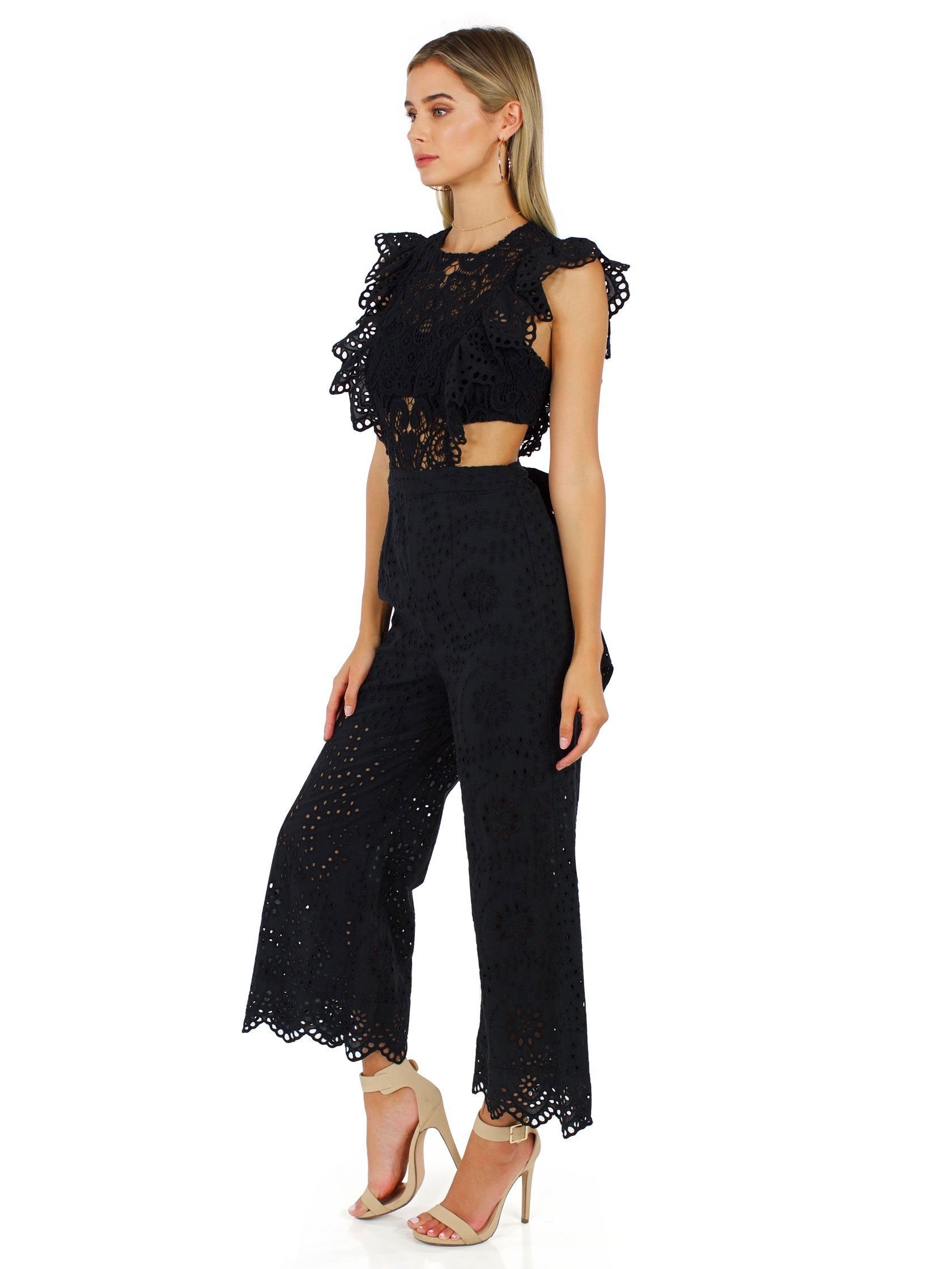 Woman wearing a jumpsuit rental from Nightcap Clothing called Eyelet Apron Jumpsuit