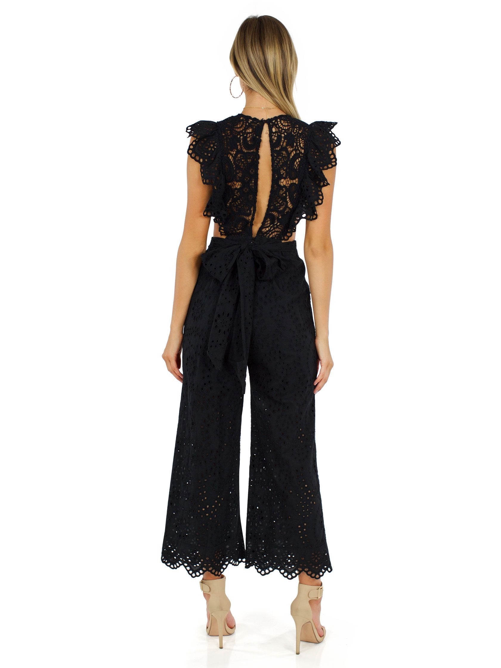 Women wearing a jumpsuit rental from Nightcap Clothing called Eyelet Apron Jumpsuit